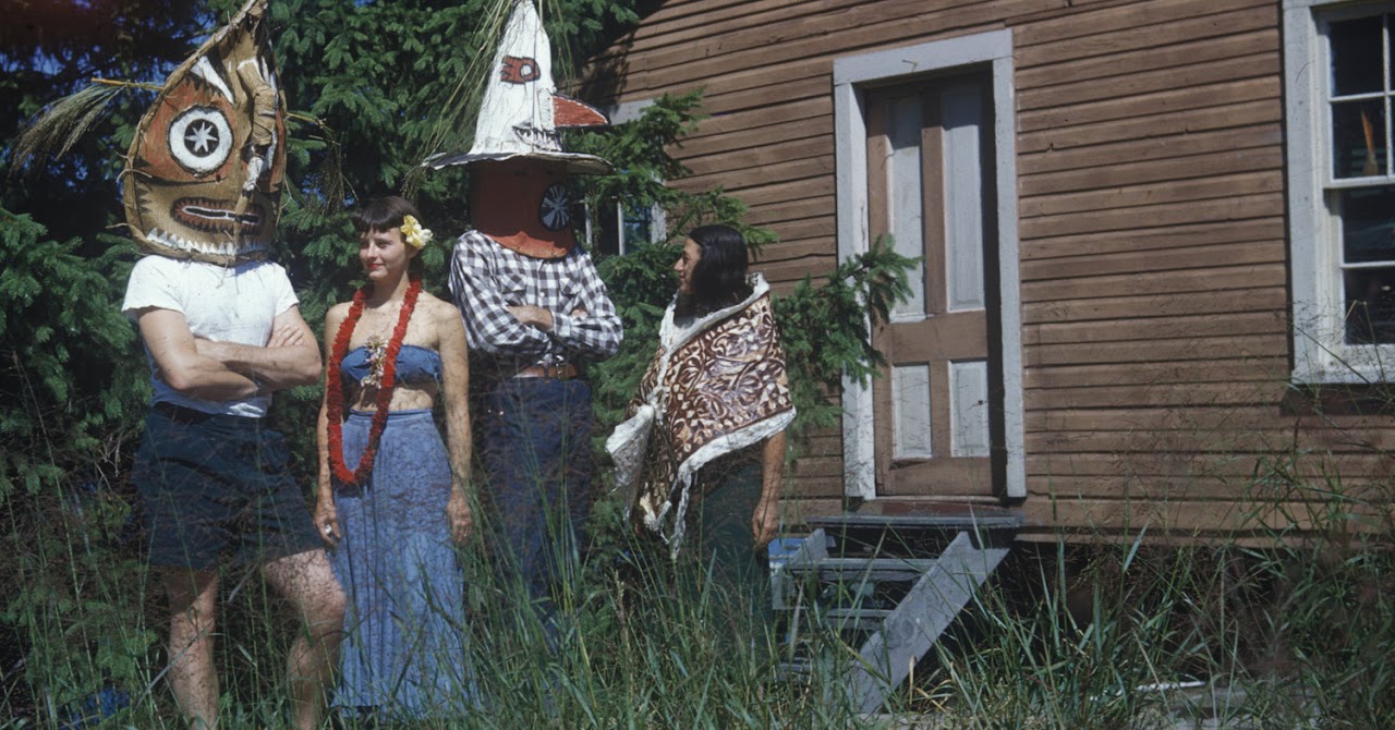 Two couples standing outside dressed in native clothing representing a variety of heritages